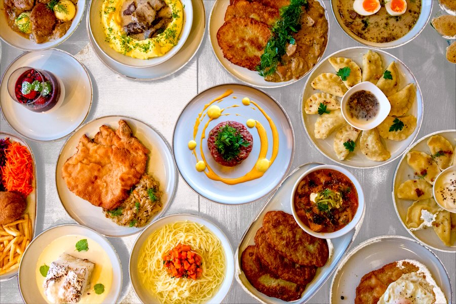 Stół zastawiony daniami Wilczyńca: tatar, pierogi, placki, zupy